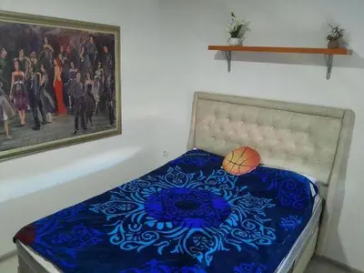 a bed in a room with a painting on the wall at Vikendica Lazar in Banja Luka