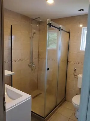 a bathroom with a shower with a sink and a toilet at Vikendica Lazar in Banja Luka