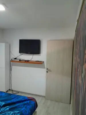 a room with a bed and a television and a door at Vikendica Lazar in Banja Luka