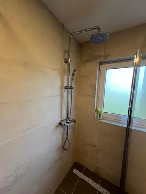 a shower in a bathroom with a window at Travnik Nature in Travnik