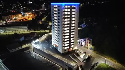 a tall white building with a blue light on it at SkyDeck8 in Cazin