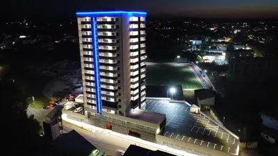 a tall building with a blue light on it at night at SkyDeck8 in Cazin