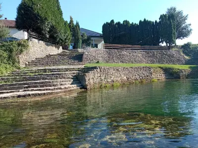 a stone wall next to a body of water at Luka Holiday House in Buševića Blatna