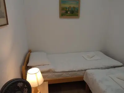 a small room with two beds and a lamp at Luka Holiday House in Buševića Blatna