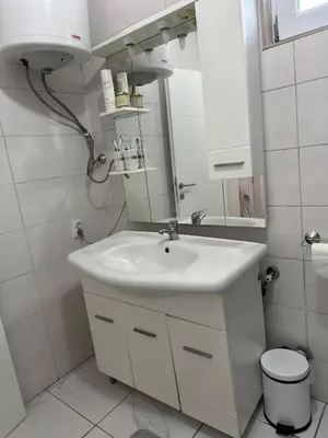a white bathroom with a sink and a mirror at Hilltop Family House Panoramic Views in Dobrnja