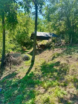 a shed with a tarp on it in the woods at Hilltop Family House Panoramic Views in Dobrnja