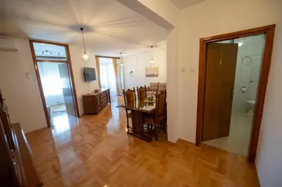 a living room with a table and a dining room at Apartman Magija in Banja Luka