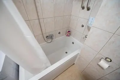 a bathroom with a white tub and a shower at Apartman Magija in Banja Luka