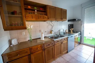 a kitchen with wooden cabinets and a sink at Apartman Magija in Banja Luka
