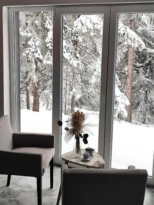 a living room with a view of snow covered trees at Lux Escape Pridolci in Kozica