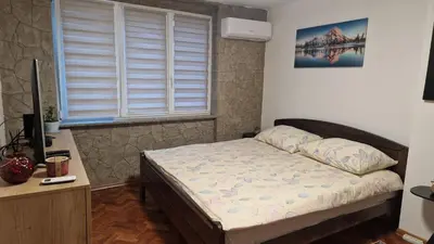 a bedroom with a bed and a desk and a window at Apartman Katja Travnik in Travnik