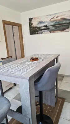 a wooden table with a chair and a painting on the wall at Apartman Katja Travnik in Travnik