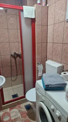 a bathroom with a shower and a washing machine at Apartman Katja Travnik in Travnik