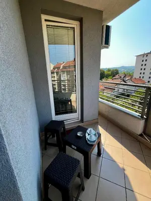 a balcony with a table and two chairs and a window at Nataša in Doboj