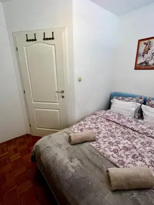a small bedroom with a bed and a door at Nataša in Doboj