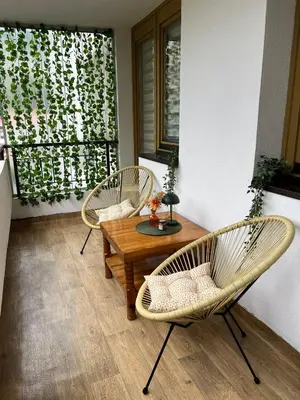 a patio with two chairs and a wooden table at EMMA apartman in Travnik
