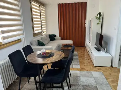 a living room with a table and a couch at EMMA apartman in Travnik
