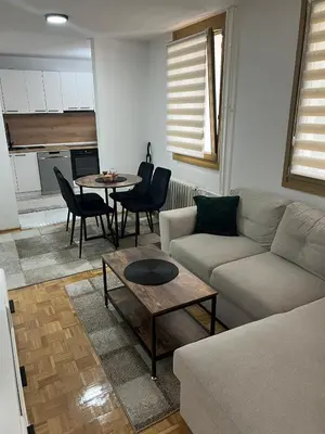 a living room with a couch and a table at EMMA apartman in Travnik