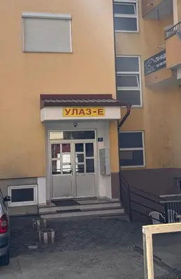 a entrance to a building with a wissos sign on it at Beauty Room Apartman in Prnjavor