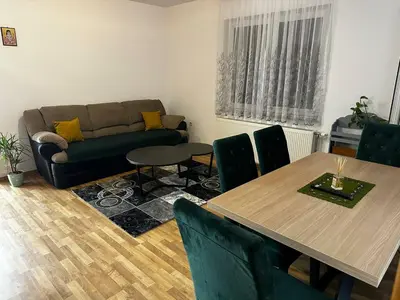 a living room with a table and a couch at Beauty Room Apartman in Prnjavor