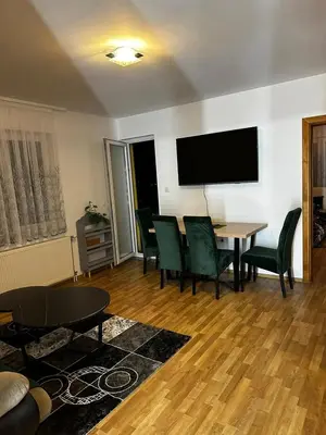 a living room with a table and chairs and a flat screen tv at Beauty Room Apartman in Prnjavor