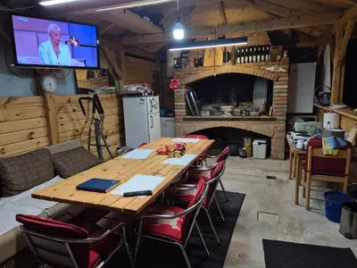 a dining room with a table and a tv in a kitchen at Sobe Kovacevic