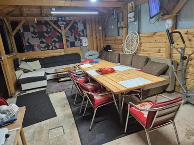 a living room with a wooden table and chairs at Sobe Kovacevic