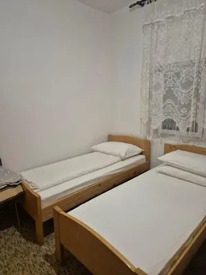 two twin beds in a room with a window at Sobe Kovacevic