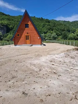a small wooden barn in a dirt field at Whisper of the Pliva in Šipovo