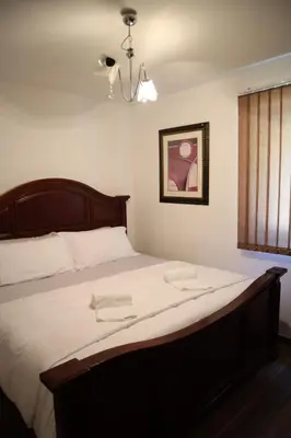 a bedroom with a large bed with white sheets at Villa Duboka Bugojno in Bugojno