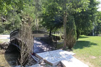 a black bridge with a bench in a park at Villa Duboka Bugojno in Bugojno