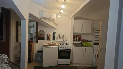 a small kitchen with white cabinets and a stove at 4 Room - 2 story Apartment Kuckovic in Bihać