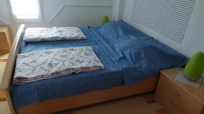 a bedroom with a bed with a blue comforter at 4 Room - 2 story Apartment Kuckovic in Bihać