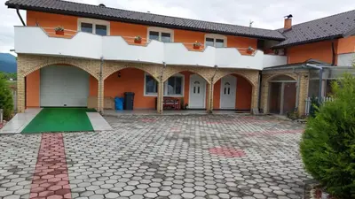 an orange house with a courtyard in front of it at 1 Room Suite Kuckovic in Bihać
