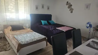 a bedroom with two beds and a table at 1 Room Apartment Kuckovic in Bihać