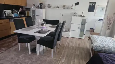 a dining room table with black chairs in a kitchen at 1 Room Apartment Kuckovic in Bihać