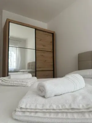 two towels on a bed in front of a mirror at Ada by AA Stan na dan in Železnička Stanica Incel