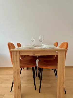 a wooden table with four chairs and wine glasses at Ada by AA Stan na dan in Železnička Stanica Incel