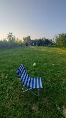 a blue chair in a field with a frisbee at MALA KOLA - Weekend House in Banja Luka