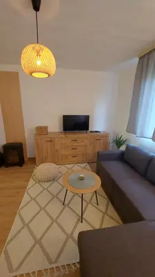 a living room with a blue couch and a table at MALA KOLA - Weekend House in Banja Luka