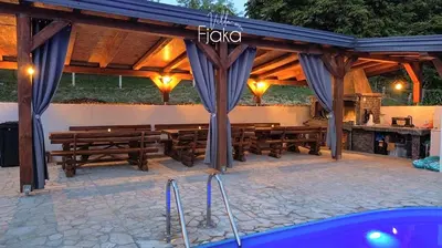 a pavilion with wooden benches and a table at Villa Fjaka in Banja Luka