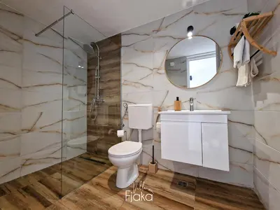a bathroom with a toilet and a sink and a mirror at Villa Fjaka in Banja Luka