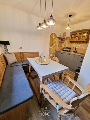 a kitchen and living room with a table and chairs at Villa Fjaka in Banja Luka