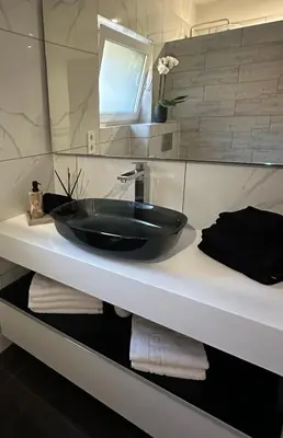a bathroom with a black sink on a counter at NADA Home in Čelebić