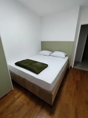 a white bed with a green blanket on top of it at AnyBL03 in Železnička Stanica Incel