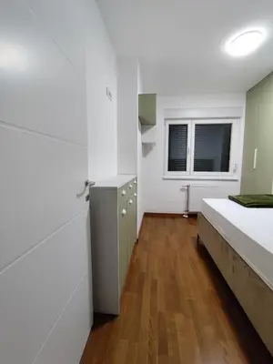a bedroom with white walls and a bed and wooden floors at AnyBL03 in Železnička Stanica Incel