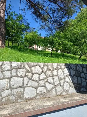 a stone wall with trees in a park at Villa in Breza Village