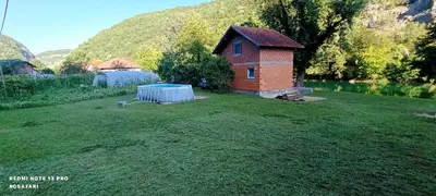 a small brick house in the middle of a yard at Holiday home una in Bosanska Krupa