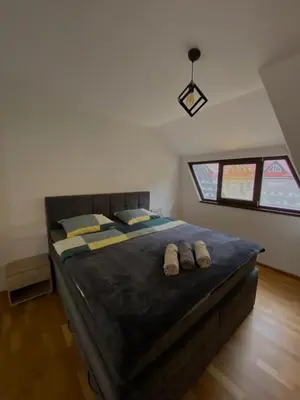 a bedroom with a large bed with slippers on it at Vares Luxury Apartment in Vareš