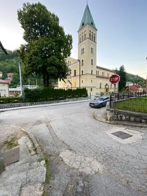 a church with a stop sign in front of a street at Vares Luxury Apartment in Vareš